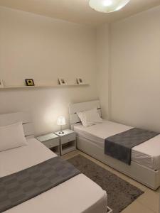 a bedroom with two beds and a lamp on a table at Entire Apartment with Garden in Sheikh Zayed