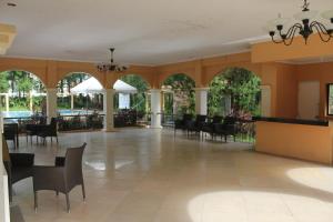 ein Esszimmer mit Tischen und Stühlen und Fenstern in der Unterkunft Holiday Home in Bacolod City, Philippines in Bacolod City