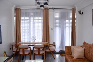 a living room with a table and chairs and a couch at Bomani -4 Summerlake in Kisumu
