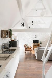 eine Küche und ein Wohnzimmer mit weißen Wänden in der Unterkunft The Henloft Cotswolds Farm Stay With Pool in Lechlade