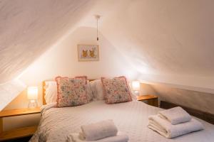 ein Schlafzimmer mit einem Bett mit zwei Kissen darauf in der Unterkunft The Henloft Cotswolds Farm Stay With Pool in Lechlade + 106 Fotos