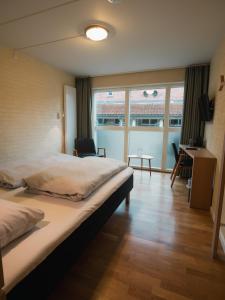 um quarto de hotel com uma cama grande e uma escrivaninha em Strandhotel Klinten em Rødvig mais 42 fotografias