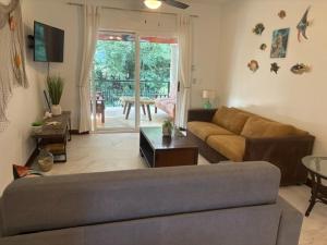 una sala de estar con un sofá y una mesa en Jazmin Del Sol steps away from Playa Potrero !!, en Potrero