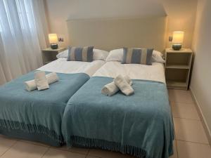 two beds in a bedroom with towels on them at Hola La Fuente in Puerto de Mogán