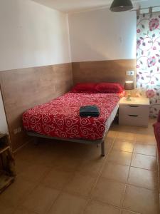 a bedroom with a bed with a red comforter at El Doblao del Rey in Torrejón del Rey +7 photos