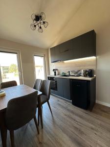 a kitchen and dining room with a table and chairs at Georgia Suites in Lyubimets