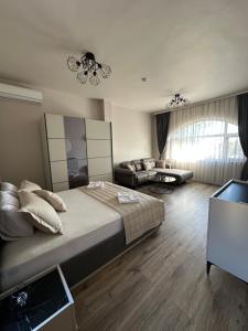 ein Schlafzimmer mit einem großen Bett und einer Couch in der Unterkunft Georgia Suites in Lyubimets