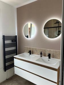 a bathroom with two sinks and two mirrors at L'Ecrin Angevin in Le Plessis-Grammoire +13 photos