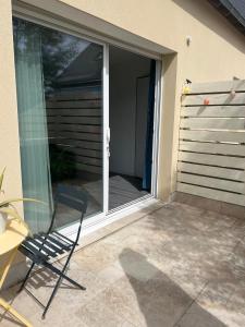 a chair sitting on a patio in front of a sliding glass door at L'Ecrin Angevin in Le Plessis-Grammoire