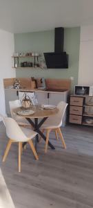 a dining room with a table and two white chairs at L'Ecrin Angevin in Le Plessis-Grammoire