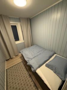 una piccola stanza con un letto e una finestra di Langhaugen a Kabelvåg