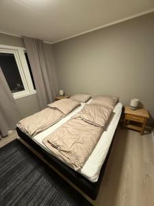 an unmade bed in a bedroom with a window at Langhaugen - Kabelvåg in Kabelvåg