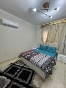 Un dormitorio con una cama con sábanas azules y una alfombra. en متاحه الان شقه ف المستقبل غرفتين نوم حمام مطبخ ريسبنش واي فاي, en Sheikh Zayed 5 fotos más