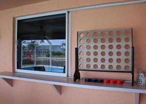 okno na ścianie z czerwonymi kubkami na półce w obiekcie Family friendly home on water with kayaks and pool w mieście Cape Coral