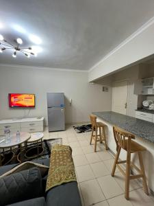 Una cocina y una sala de estar con un sofá y una mesa. en متاحه الان شقه ف المستقبل غرفتين نوم حمام مطبخ ريسبنش واي فاي, en Sheikh Zayed
