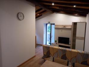 a living room with a clock on the wall and a couch at House Guilho in Reriz