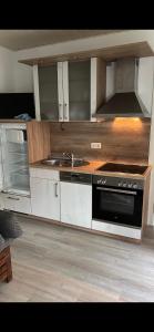 une grande cuisine avec une cuisinière et un évier dans l'établissement Ferienwohnung Kati, à Zinnowitz