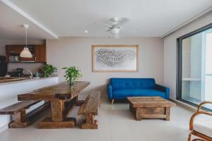 ein Wohnzimmer mit einem Tisch und einem blauen Sofa in der Unterkunft SkyMar Luxury 27 in Cartagena de Indias
