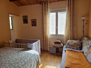 a bedroom with a crib and a window at Сocon bien douillet in Saint-Denis-dʼOléron