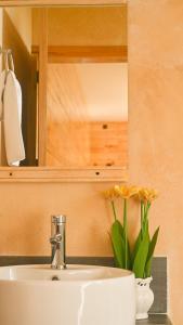 ein Waschbecken mit einem Spiegel und einer Vase mit Blumen in der Unterkunft San José del Pacífico- Cabañas Camino al Cielo 2 in San Mateo Río Hondo