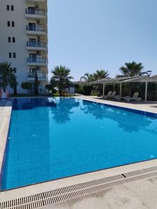 une grande piscine bleue à côté d'un immeuble dans l'établissement Caesar Blue Resort Spa Sea view apartment H-49, à Vrysoules