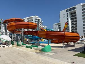 - un toboggan aquatique dans un parc avec des personnes dans l'établissement Caesar Blue Resort Spa Sea view apartment H-49, à Vrysoules