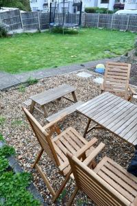 two wooden chairs and a picnic table in a yard at The ChurchHill in East Barnet