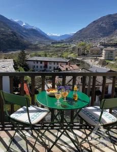 ein Tisch mit zwei Gläsern Wein auf einem Balkon in der Unterkunft AlpNest in Saint Vincent