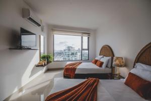 ein Hotelzimmer mit zwei Betten und einem Fenster in der Unterkunft SkyMar Luxury 27 in Cartagena de Indias + 61 Fotos