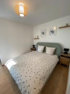 ein Schlafzimmer mit einem großen Bett mit einer weißen Tagesdecke in der Unterkunft Cosy appartement proche saint emilion in Le Fieu