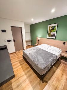 a bedroom with a large bed and a green wall at Habitat Ochentayuno in Medellín +76 photos