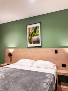 a bedroom with a bed and a picture on the wall at Habitat Ochentayuno in Medellín