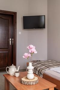 une chambre avec un lit et un vase de fleurs sur une table dans l'établissement Pokoje gościnne Zuzanna Krupa, à Kluszkowce