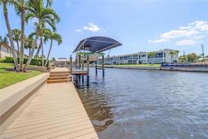 przejście obok rzeki z palmami i budynku w obiekcie Family friendly home on water with kayaks and pool w mieście Cape Coral +30 zdjęć