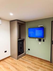 a room with a flat screen tv on a wall at Habitat Ochentayuno in Medellín