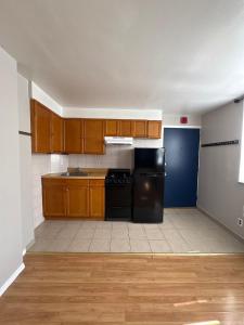 a kitchen with a black refrigerator and wooden cabinets at Cabin in Tybee Island in Tybee Island