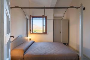 a bedroom with a bed and a window at Villa Corallo Cala Bianca in Castellammare del Golfo