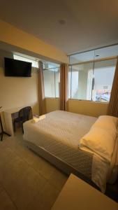 a bedroom with a bed and a desk and a television at Hotel Rodilla in Ayacucho +21 photos