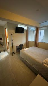 阿亚库乔Hotel Rodilla的一间卧室，里面有一张床、一张桌子和一台电视。