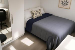 a small bedroom with a bed and a desk at MODERNO NUEVO Luminoso WI-FI PLAZA DEL PILAR 2 in Zaragoza
