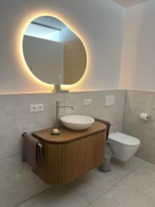 ein Badezimmer mit Waschbecken, Spiegel und Toilette in der Unterkunft Apartment Fidelia in Sankt Anton im Montafon