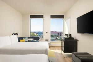 una camera d'albergo con un letto e una TV a schermo piatto di Aloft Strasbourg City Centre a Strasburgo