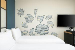 una camera con letto e parete con TV di Aloft Strasbourg City Centre a Strasburgo Altre 34 foto