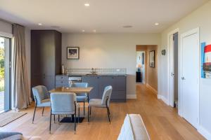uma cozinha e sala de jantar com mesa e cadeiras em The Keep at Woodside Bay em Waiheke Island