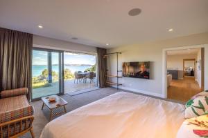 um quarto com uma cama e vista para o oceano em The Keep at Woodside Bay em Waiheke Island