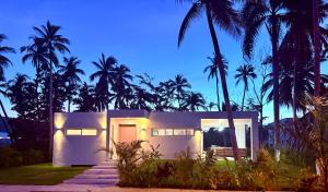une maison blanche avec des palmiers la nuit dans l'établissement Charming Villa GUGI in Playa Coson, à Las Terrenas