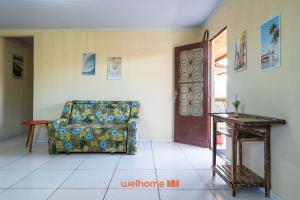 ein Wohnzimmer mit einem Stuhl und einem Tisch in der Unterkunft Casa em Cabo Frio com Churrasqueira e Praia in Barra de São João