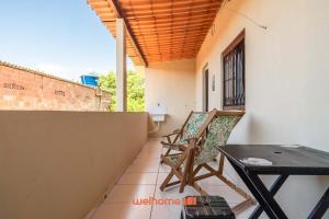 ein Balkon mit Tisch und Stühlen auf einem Gebäude in der Unterkunft Casa em Cabo Frio com Churrasqueira e Praia in Barra de São João + 12 Fotos