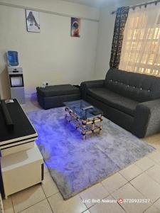 纳库鲁LnC bnb的带沙发和咖啡桌的客厅