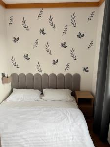 ein Schlafzimmer mit einem Bett mit schwarzen Schmetterlingen an der Wand in der Unterkunft Apartment U345 - Aparthotel Vučko Jahorina - private host in Jahorina